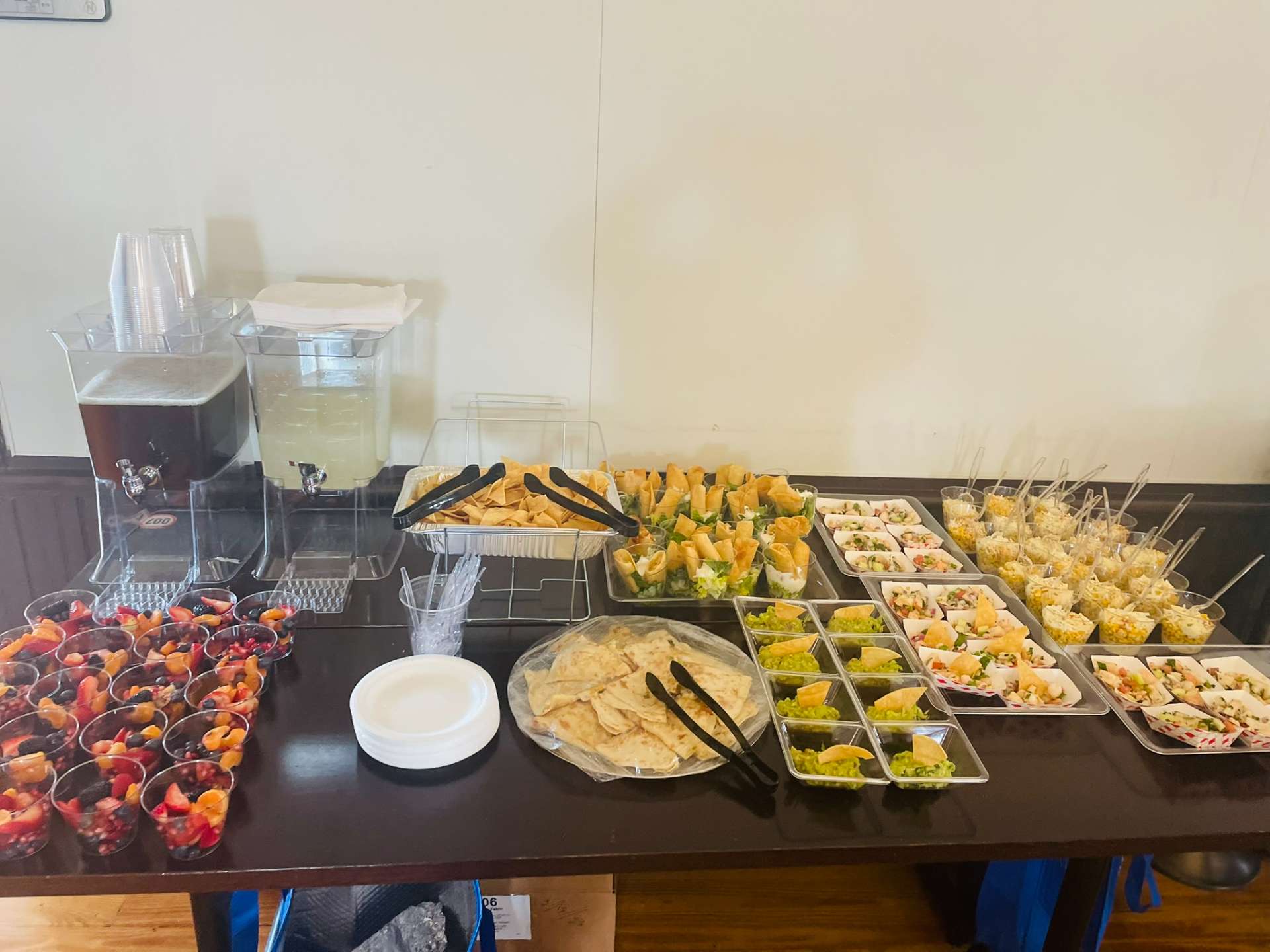 Mexican catering buffet with guacamole, quesadillas, tortilla chips, ceviche, and fresh beverages from Cafe Mona.